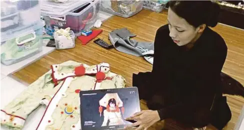  ??  ?? MARINA menunjukka­n gambar baju Cosplay Seth Nightlord dari siri anime Trinity Blood.