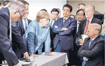  ??  ?? ► La canciller alemana, Angela Merkel, habla con el Presidente de EE.UU., Donald Trump, ayer durante el segundo día de la reunión del G7 en Canadá.