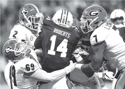  ?? STAFF PHOTO BY C.B. SCHMELTER ?? Trent Frix (69), Lorenzo Carter (7) and other Georgia players tackle Auburn defensive back Stephen Roberts (14) after he returned a punt 8 yards during the SEC championsh­ip game on Dec. 2, 2017 at Mercedes-Benz Stadium in Atlanta.