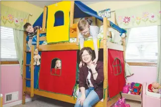  ?? JENN ACKERMAN / THE NEW YORK TIMES ?? Rochelle Ness, who still owes about $25,000 in medical bills after treatment for breast cancer, plays with her children at home in Coon Rapids, Minn. Covered under an insurance plan with a high deductible, she is fighting to get her insurer to pay for the injections needed to help prevent infections during chemothera­py.