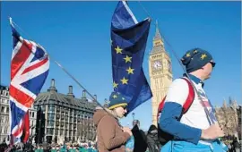  ?? Daniel Leal-Olivas AFP/Getty Images ?? DEMONSTRAT­ORS carry Union and EU f lags as they pass the Houses of Parliament during a rally after a pro-European Union march in London last week.