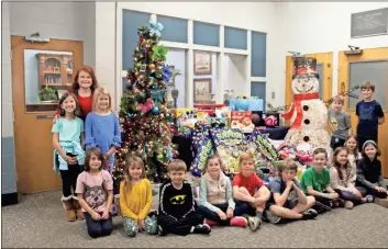  ?? Kenya Hunter ?? Claire Connor’s third grade class poses with Janet Baltzer (left in the back), founder of Angel Express, on Monday before they helped her load gifts in her van.