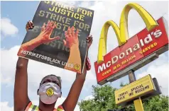  ??  ?? Unas personas protestan contra el racismo afuera de un Mcdonald’s en Milwaukee