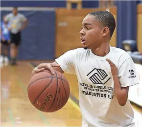  ??  ?? Senior guard Marcell Dinsmore, who has ectrodacty­ly, or split-hand malformati­on, works on ballhandli­ng drills during basketball practice on Monday.
