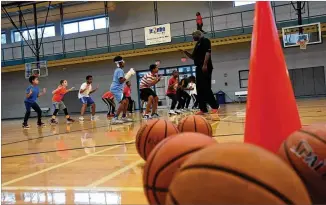  ?? HYOSUB SHIN / HYOSUB.SHIN@AJC.COM ?? As kids inevitably complain of boredom during their school break this time of year, former pro basketball player Rodney Zimmerman runs a youth developmen­t camp at Lucky Shoals Park’s Community Recreation Center in Norcross. The program, he says, is about more than physical activity. It’s also about teaching success and elevating how kids perceive their abilities.