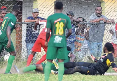 ??  ?? Boys’ Town’s new signing Bebeto McDonald (partially hidden) scrambles in an added-time goal to level the score at 1-1 while Humble Lion’s goalie (on ground) and defenders look on.