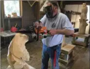  ?? BILL DEBUS — THE NEWS-HERALD ?? Chainsaw artist Chris Pascoe works on a bear that he is carving at his Perry Township workshop. He recently opened the workshop to expand his business, which is called Carvings by Chris.