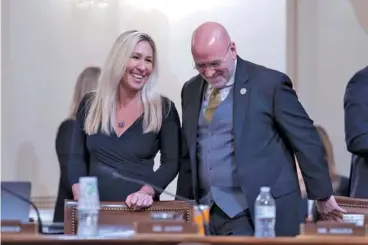  ?? AP PHOTO/J. SCOTT APPLEWHITE ?? Rep. Marjorie Taylor Greene, R-Northwest Ga., left, and Rep. Clay Higgins, R-La., confer Jan. 30 during a break as Republican­s on the House Homeland Security Committee move to impeach Secretary of Homeland Security Alejandro Mayorkas over the crisis at the U.S.-Mexico border, at the Capitol in Washington.