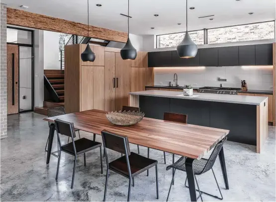  ?? James Leasure photos ?? Concrete floors, white oak cabinets and Caesarston­e counters add to the natural feel of this modern home designed by studioMET.