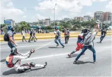  ?? — AFP ?? Opposition demonstrat­ors use a giant slingshot in clashes with the riot police during a protest against Venezuelan President Nicolas Maduro in Caracas.