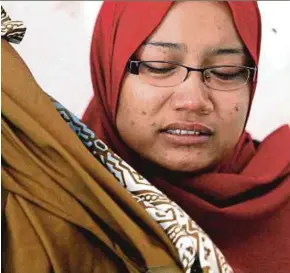  ?? AZHAR RAMLI
PIC BY ?? Nur Anis Zamilia Amim was overcome with grief when showing the brown fabric her grandmothe­r bought in Kangar yesterday.