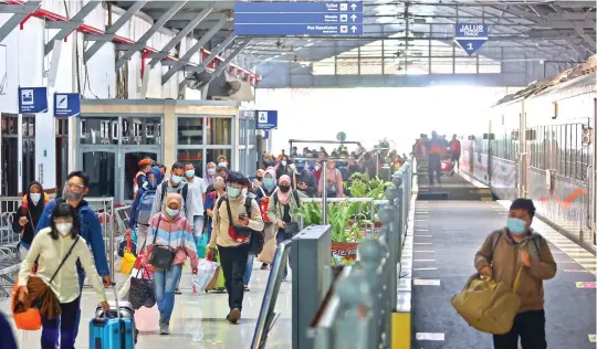  ?? AHMAD KHUSAINI/JAWA POS ?? HARI INI BEKERJA LAGI: Warga Surabaya mulai berdatanga­n di Stasiun Pasar Turi setelah bepergian dari luar kota.