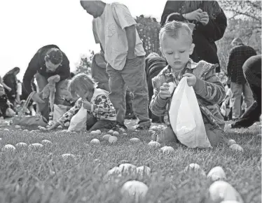  ?? SCOTT MORGAN/ROCKFORD REGISTER STAR ?? Mason Freeman, 3, of Rockford, puts Easter eggs in a bag during the Rockford Park District’s egg hunt Saturday, April 7, 2012, at Anna Page Park in Rockford.