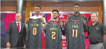  ?? THE ASSOCIATED PRESS ?? Atlanta Hawks general manager Travis Schlenk, left, stands with coach Mike Budenholze­r, right, and with draft picks John Collins, Tyler Dorsey and Alpha Kaba on Monday in Atlanta.