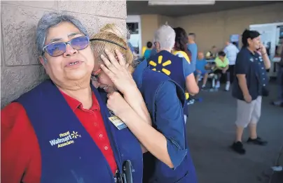  ?? MARK LAMBIE/THE EL PASO TIMES ?? Walmart employees grieve after 20 people were killed and 26 injured during a shooting rampage in the store. Police say only one person opened fire, although at least one witness said there were more shooters.