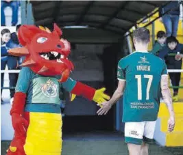  ?? ?? Dragoncito, mascota del CPC, choca la mano con Viñuela. ▷