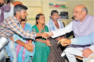  ?? — DC ?? BJP national president Amit Shah greets a family during his door-to-door campaign to raise awareness on the Modi government’s achievemen­ts at Peddadevul­apalli, Nalgonda district on Tuesday.