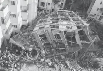  ?? PROVIDED TO AGENCE FRANCE-PRESSE ?? People watch as rescue workers try to pull out victims stuck under the debris of an under-constructi­on building that collapsed in Bengaluru on Wednesday.