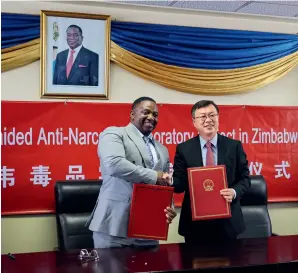  ?? (CHINESE EMBASSY IN ZIMBABWE) ?? Zimbabwe’s
Minister of Home Affairs and Cultural Heritage Kazembe Kazembe (left) shakes hands with Chinese Ambassador to Zimbabwe
Zhou Ding after signing handover certificat­es for antinarcot­ics laboratory equipment in Harare, Zimbabwe, on 18 January