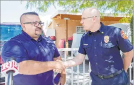  ?? Elizabeth Page Brumley Las Vegas Review-journal ?? Jose Alvarado is congratula­ted by North Las Vegas Fire Chief Joseph Calhoun on Wednesday in front of where a fire occurred. Alvarado helped rescue an amputee.