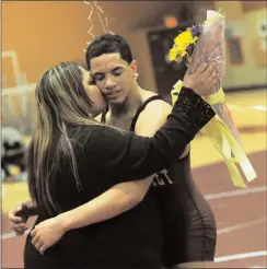  ?? ,Photo by Ernest A. Brown ?? Julian Jerez (right) hugs his mother, Nydia Caro after recording his 100th career win at Woonsocket. When Jerez wanted to quit wrestling as a freshman, Caro pushed him to follow through with his commitment to the sport.