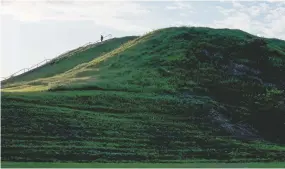  ?? WHITNEY CURTIS/NEW YORK TIMES ?? Monks Mound at Cahokia Mounds State Historic Site in Cahokia, Ill., in May 2019. Cahokia, across the Mississipp­i from present-day St. Louis, was a city of roughly 20,000 people at its peak in the 1100s, but was largely abandoned by 1350. Excavation­s at Cahokia, famous for its pre-Columbian mounds, challenge the idea that residents destroyed the city through wood clearing.