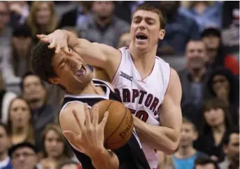  ?? NATHAN DENETTE/THE CANADIAN PRESS ?? Raptors’ Tyler Hansbrough, right, lands a hard foul on Nets forward Brook Lopez during first-half play Wednesday.