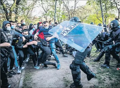  ?? DANI DUCH ?? La policía carga contra los manifestan­tes concentrad­os en el barrio
El diputado de Vox por Guadalajar­a Ángel López resultó herido de una pedrada por la contienda y fue trasladado al hospital donde anoche permanecía ingresado. El líder de Vox responsabi­lizó al ministro del Interior, Fernando Grande-marlaska, de los disturbios y dijo que “debe ir a prisión” por ello. El Samur atendió a al menos trece personas heridas.