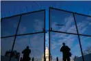  ?? Photograph: Kent Nishimura/Los Angeles Times/ REX/Shuttersto­ck ?? National Guard troops stand behind security fencing with the dome of the Capitol building behind them, on Saturday.