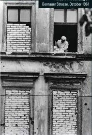  ??  ?? Something to hide An East German bricks up a window in a building on Bernauer Strasse, October 1961