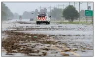  ?? Arkansas Democrat-Gazette/STEPHEN B. THORNTON ?? A Burlington Northern Santa Fe Railway truck drives Wednesday through water along a debris-strewn stretch of U.S. 63 east of Portia in Lawrence County.