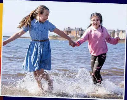  ??  ?? Making a splash: Isabella Adamson, ten, and Miya Lindsay, eight, at Troon beach