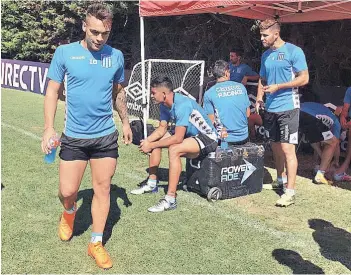  ??  ?? ► Lautaro Martínez se refresca durante la práctica de Racing de ayer, en San Carlos de Apoquindo.