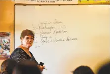  ?? Robyn Beck / AFP via Getty Images ?? Maria Valenzuela reviews possible test questions with the help of fellow students in a U.S. citizenshi­p test preparatio­n class in 2016 in Perris (Riverside County).