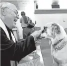  ?? THE OKLAHOMAN FILE ?? Norah the dog is blessed during a 2016 service for pets at Church of the Good Shepherd in Edmond.