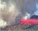  ?? ERIC PAUL ZAMORA/ THE FRESNO BEE VIA AP ?? A plane drops fire retardant on the Washburn Fire on Monday as it burns near the south entrance of Yosemite National Park, Calif.