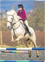  ??  ?? Ashley Sinclair, top, leads daughter Eva Sinclair, 8, on Dolly, while Emily Sinclair, 10, left, guides Bubbles, and Hannah Binnie, 12, jumps with Belle