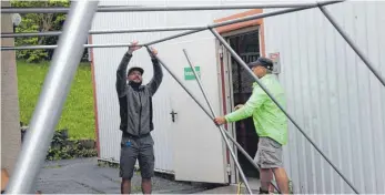  ?? FOTO: CAROLINE MESSICK ?? Benny Tabor (links) und Stefan Krumbacher bauen das Festzelt für den Badgers Cup auf.