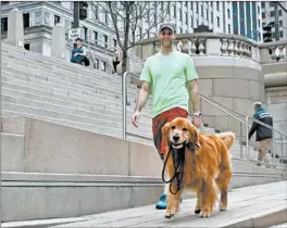  ?? BETTINA CHANG/CHICAGO MAGAZINE ?? David Duncan walks with his dog Sporty along the Chicago Riverwalk in 2016.