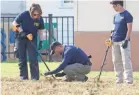  ??  ?? Members of the FBI look for evidence in a field next to the First Baptist Church in Sutherland Springs, Texas. COURTNEY SACCO/USA TODAY NETWORK