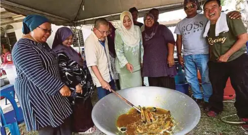  ??  ?? ISA bersama isteri, Puan Sri Bibi Sharliza Mohd Khalid membantu memasak ikan keli bersama penduduk setempat di Kampung Pachitan, Port Dickson.