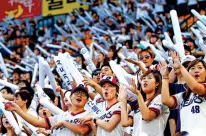  ?? HYE SOO NAH/ASSOCIATED PRESS FILE PHOTO ?? Fans of the South Korean baseball team Doosan Bears sing songs while performing dance routines in 2021 at Jamsil Stadium in Seoul, South Korea.