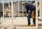  ?? ROGELIO V. SOLIS — THE ASSOCIATED PRESS ?? A carpenter aligns a beam for a wall frame at a new house site in Madison County, Miss. Housing has been one of the standout performers during the pandemic-triggered recession, but many economists believe that the surge in home building and sales over the past year may begin to slow, especially for singlefami­ly homes.