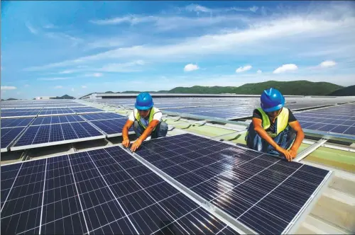  ?? YAO FENG / FOR CHINA DAILY ?? Workers install solar power generation panels in Dinghai district of Zhoushan, Zhejiang province, on July 9.