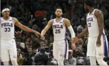  ?? DAVID BANKS — THE ASSOCIATED PRESS ?? Philadelph­ia 76ers guard Ben Simmons (25) walks between forward Tobias Harris (33) and center Joel Embiid (21) after making a basket against the Chicago Bulls during the second half of an NBA basketball game Saturday in Chicago.