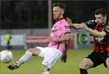  ??  ?? Wexford Youths centre-forward Danny Furlong lays the ball off under pressure from Dan Byrne.