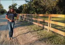  ?? KRISTINA WEBB / THE PALM BEACH POST ?? Laura Danowski stands in front of her home on South E Road on Wednesday to show where her property line is and where the road is being graded. She says conditions have deteriorat­ed badly and longrange decisions must be made.