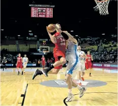  ?? AP FILE PHOTO ?? Canada’s Dwight Powell, left, goes for a shot over Uruguay’s Hernando Caceres, right, during a FIBA Americas Championsh­ip basketball game in Mexico City in a file photo from 2015.