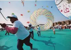  ??  ?? BEBERAPA peserta menerbangk­an layang-layang berbentuk bulatan pada Festival Layang-layang Antarabang­sa di Ahmedabad, India semalam. - Reuters