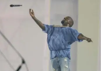  ?? STEVE RUSSELL/TORONTO STAR ?? Kanye West tosses his microphone into the air after it cut out during his Pan Am closing ceremony set on Sunday.